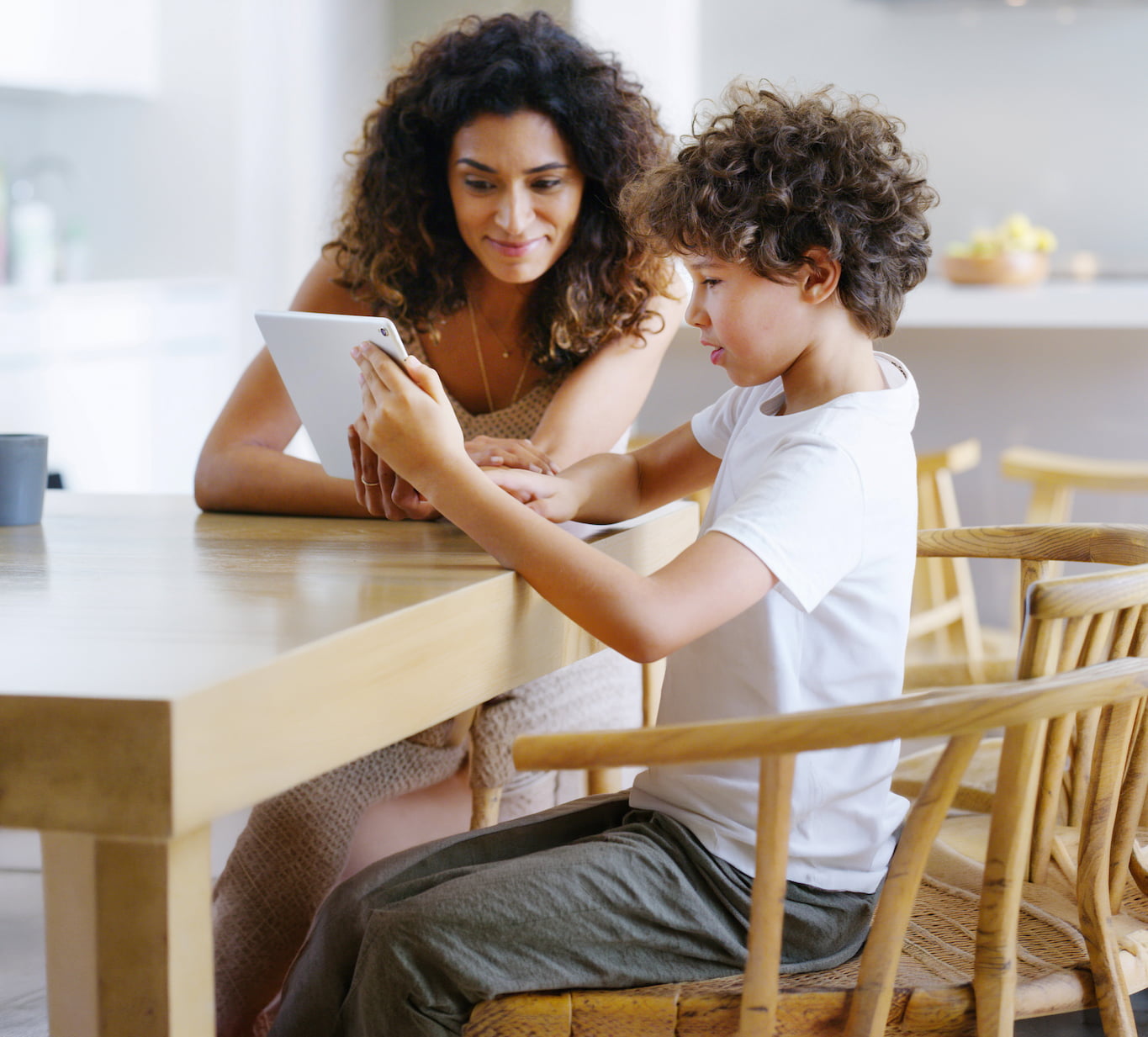 Woman, tablet and child for education, elearning and studying for future and knowledge. Mother, student and kitchen for teaching, homework or support for home school or development with assessment